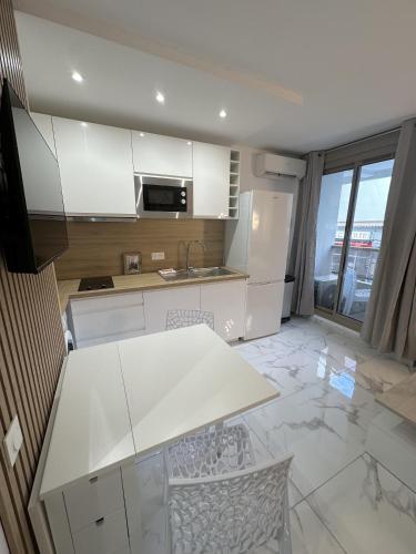 une cuisine avec des armoires blanches et un comptoir dans l'établissement Résidence Graziella Studio 107, à Juan-les-Pins