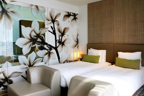 a hotel room with two beds and a chair at Crowne Plaza Changi Airport by IHG in Singapore