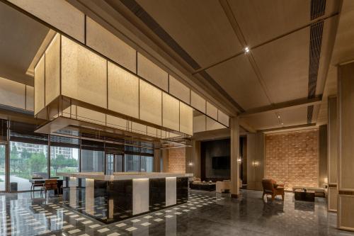 a lobby of a building with a table and chairs at Doubletree By Hilton Kaifeng in Kaifeng