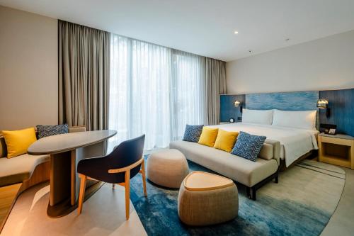 a hotel room with a bed and a couch at Crowne Plaza Changi Airport by IHG in Singapore