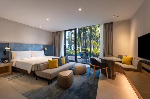 a hotel room with a bed and a living room at Crowne Plaza Changi Airport by IHG in Singapore