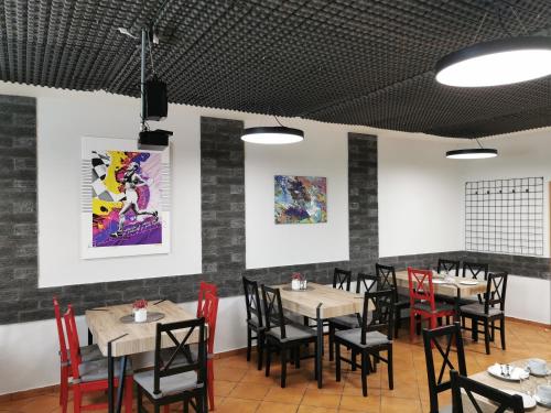 a dining room with tables and red chairs at Penzion pod Bílou Horou in Kopřivnice
