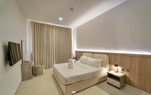 a hotel room with a bed and a television at Asfar Resorts Al Ain in Al Ain