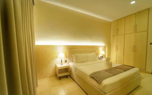 a bedroom with a bed and a night stand with two lamps at Asfar Resorts Al Ain in Al Ain