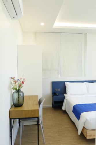 a bedroom with a bed and a table with a vase on it at Lá Riverside Boutique Hotel in Mỹ Phước