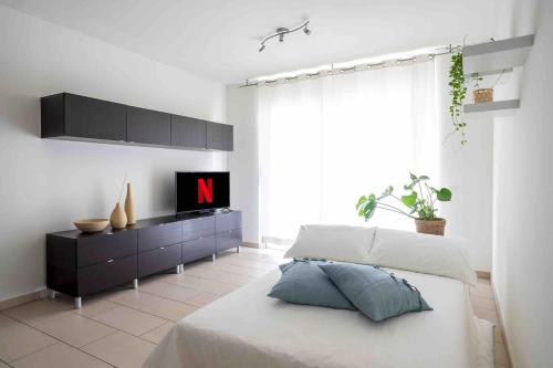 a bedroom with a bed and a tv on a dresser at Casa Luce with Private Gym and Netflix - Lugano in Viganello