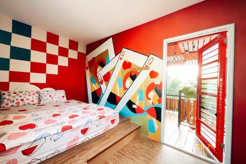 a bedroom with a bed and a colorful wall at Little Ryukyu Hermit Crab Homestay in Xiaoliuqiu