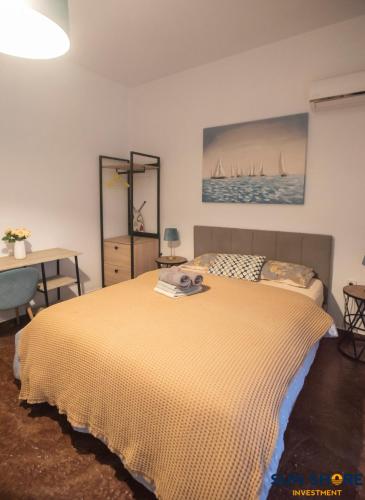 a bedroom with a bed and a painting on the wall at Explore Greece from Lovely City Centre Apartment in Chalkida