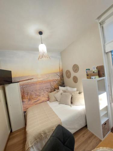 une chambre avec un lit avec un tableau sur le mur dans l'établissement Studio Saint Rémy Dieppe, à Dieppe