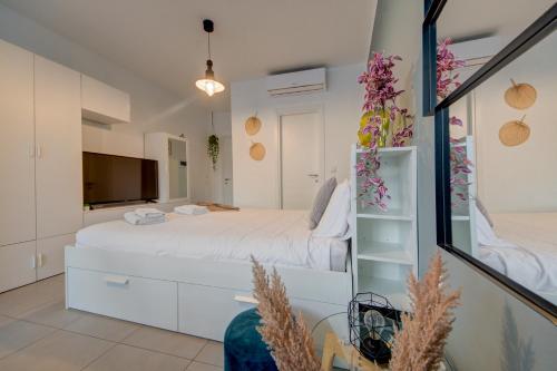 une chambre avec un lit blanc et une télévision dans l'établissement Cosy Penthouse in Hamrun - Walking distance to Valletta, à Hamrun