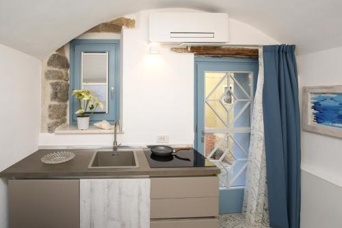 a kitchen with a sink and a window at B&B Domos Mi & Ro in Castelsardo