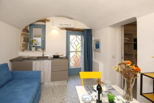 a living room with a blue couch and a table at B&B Domos Mi & Ro in Castelsardo