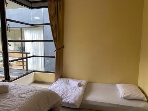 Кровать или кровати в номере Family Only Cozy Villa on Top of Bandung - De Reiz Iris Syariah 4BR