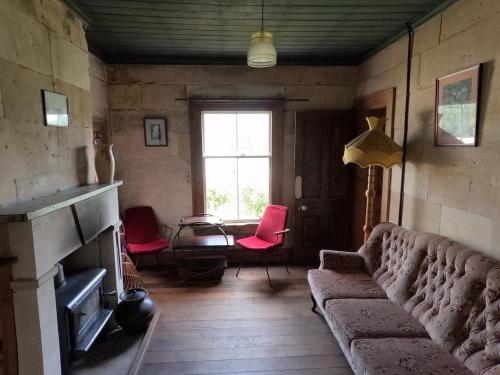 a living room with a couch and a window at Granny Grunkes Cottage in Oamaru