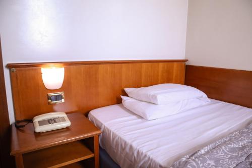 a hotel room with a bed and a phone on a table at Hotel Villa Sara in Mestre
