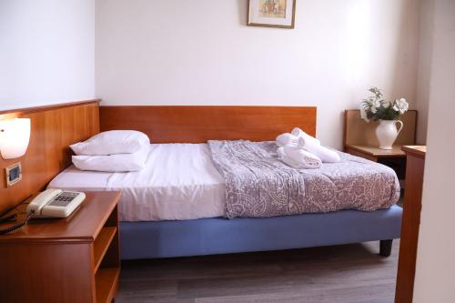 a bedroom with a bed with a desk and a telephone at Hotel Villa Sara in Mestre