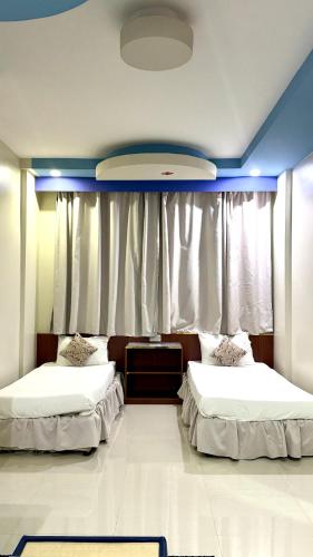a bedroom with two beds and a window at Collection O Muscat Airport Hotel Apartments in Ghursheba