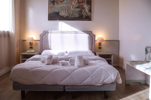 a bedroom with a large white bed with two lamps at Hotel Villa Sara in Mestre
