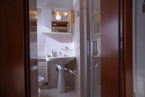 a white bathroom with a sink and a toilet at Hotel Villa Sara in Mestre