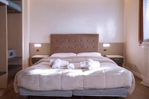 a bedroom with a large white bed with towels on it at Hotel Villa Sara in Mestre