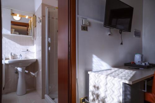 a bathroom with a sink and a television on the wall at Hotel Villa Sara in Mestre