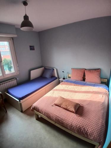 a bedroom with two beds and a window at Liberation in Mulhouse
