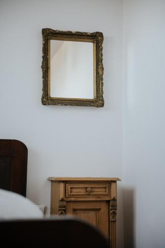a mirror on a wall next to a table at Vass Panzio in Zălan