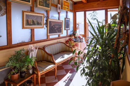 a room with two chairs and potted plants at Hotel Villa Sara in Mestre