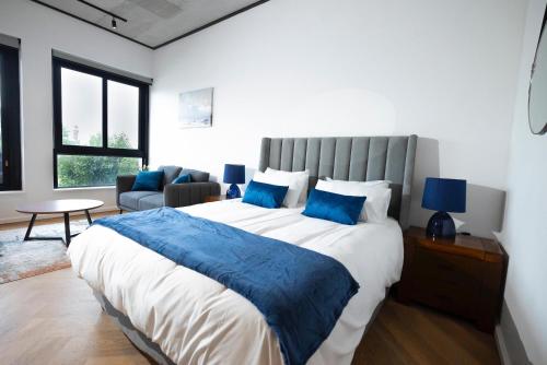 a bedroom with a large bed with blue pillows at Bridgewater Studio Century City in Century City
