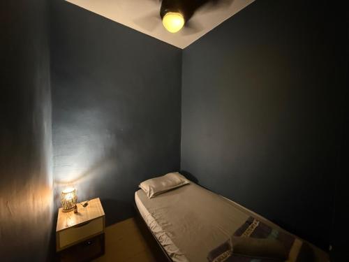 a black room with a bed and a night stand with a lamp at Manhattan Suite ITCC by 8Avenue in Kota Kinabalu