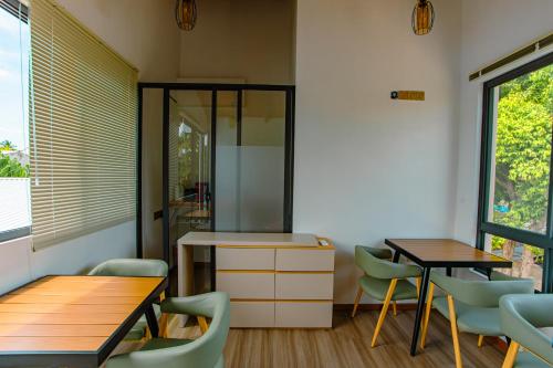 a dining room with two tables and chairs at Sunny Stay Dhigurah in Dhigurah