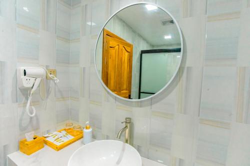 a white bathroom with a mirror and a sink at Sunny Stay Dhigurah in Dhigurah