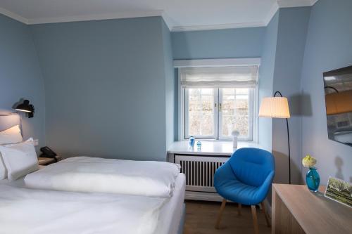 a blue room with two beds and a blue chair at Benen-Diken-Hof in Keitum