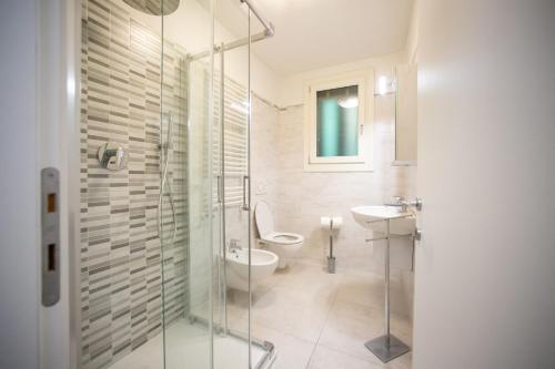 a bathroom with a shower and a toilet and a sink at Dimora Alba di Mare in Pellestrina