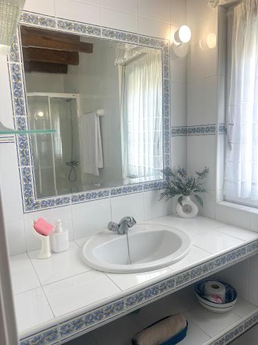 a white bathroom with a sink and a mirror at casa rural cobreces in Cóbreces