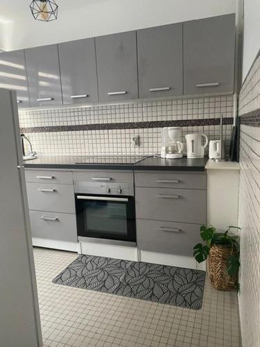 une cuisine avec des armoires blanches et un four noir dans l'établissement Élégance et classe sur axe majeur Metz T2, à Metz