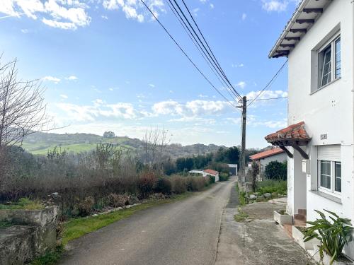 an empty road next to a white house at casa rural cobreces in Cóbreces