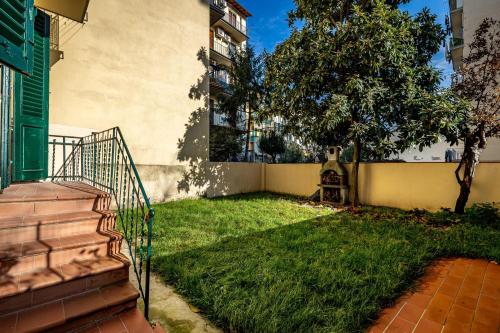a house with a yard with a staircase and grass at YD elegant apt with garden in Florence