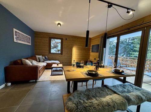 un salon avec une table et un canapé dans l'établissement Alchimie C11 - Multipass inclu, à Châtel