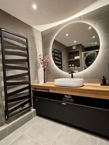 une salle de bain avec un lavabo et un miroir dans l'établissement Alchimie C11 - Multipass inclu, à Châtel