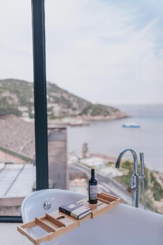 a bath tub with a bottle of alcohol sitting on it at Without Asking East or West in Zhoushan