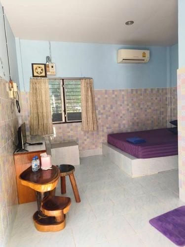 a bedroom with a bed and a table and chairs at Wanna House in Prachuap Khiri Khan