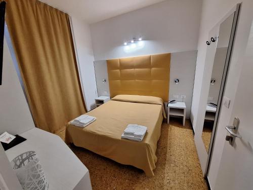 a small room with a bed and a mirror at Hotel Villa Costa in Celle Ligure