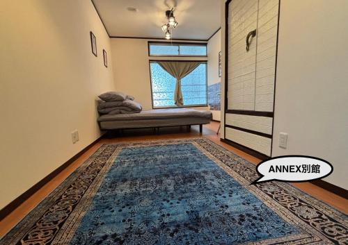 a living room with a couch and a window at 777 Takamatsu Guest House in Takamatsu
