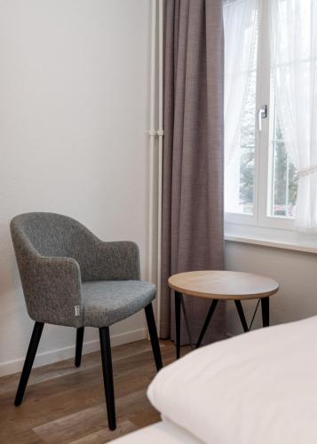 a chair and a table in a room with a window at Hotel Restaurant Kreuz in Kaiserstuhl