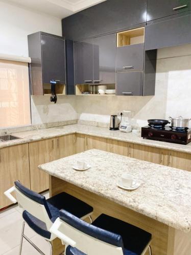 a kitchen with a counter and two chairs and a table at 4-bedroom apartment in Abuja