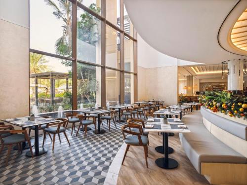 a restaurant with tables and chairs and windows at Rixos Al Mairid Ras Al Khaimah - Ultra All Inclusive in Ras al Khaimah