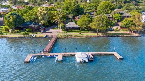 a dock with a boat on the water at Knysna Lagoon - Summer Breeze in Knysna