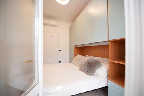 Cette petite chambre comprend un lit avec des placards blancs. dans l'établissement La Casa del Lago, à Manerba del Garda