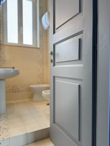 a door to a bathroom with a toilet and a sink at B&B Assteas in Montesarchio